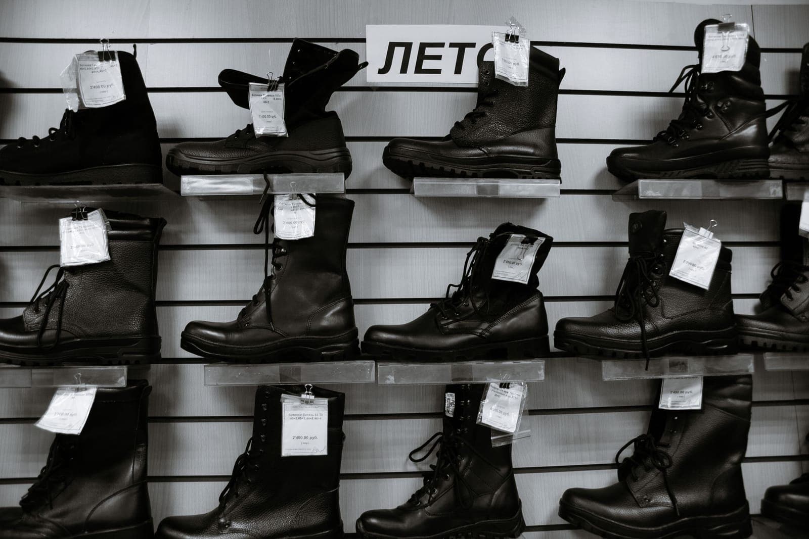 High leather boots with laces lined up on shelves, in black and white