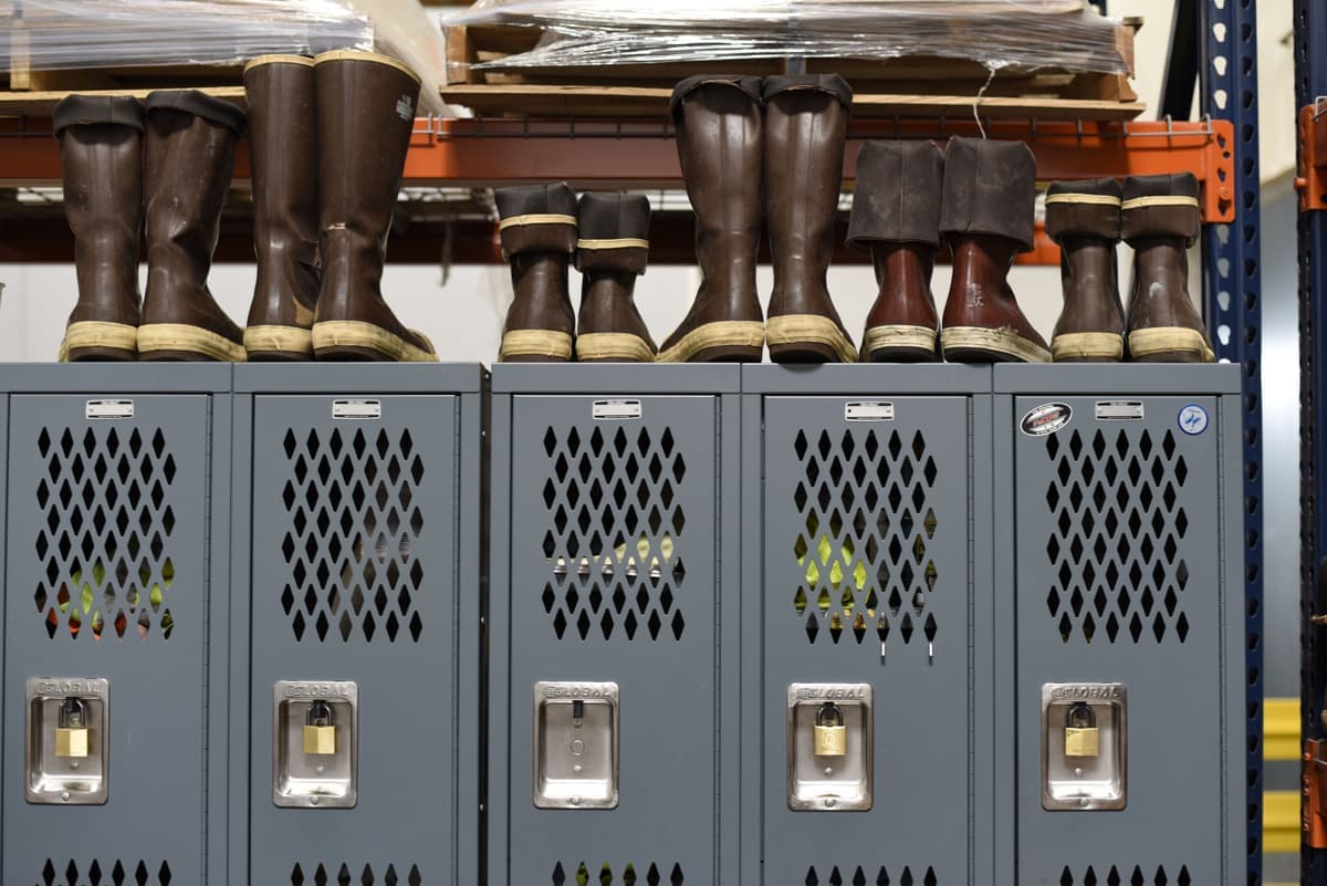 Wet boots draining on a rubber boot tray inside an entryway
