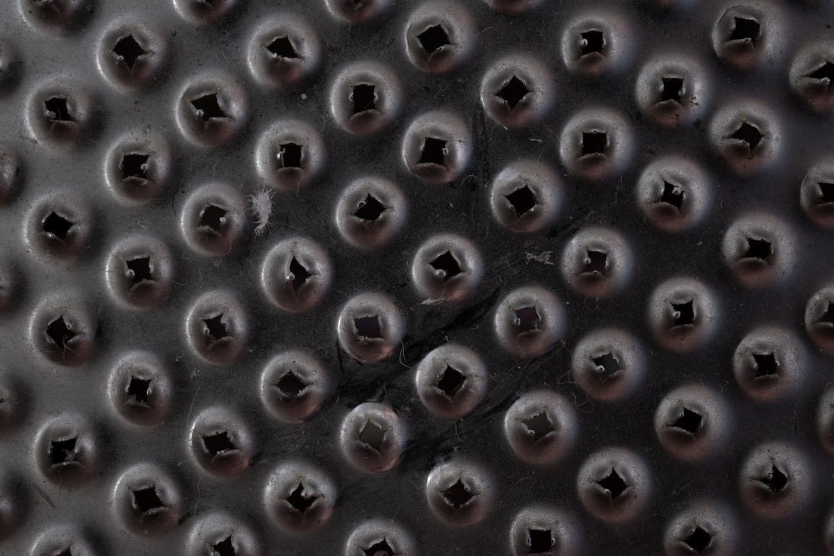 A textured dirt-trapping door mat with grit caught in its surface