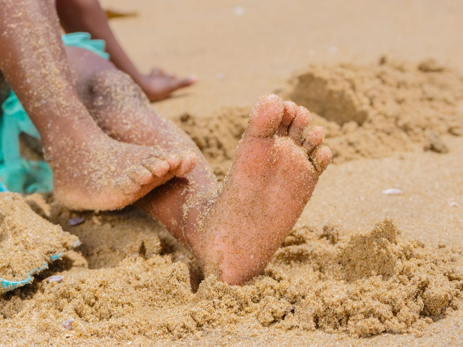 Close-up of sandy bare feet on a beach