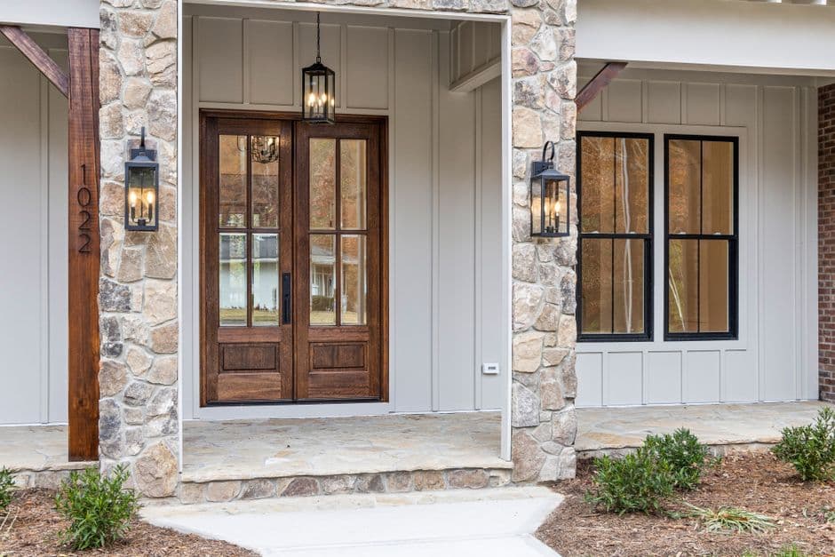 A stone house facade with wide wooden double front doors
