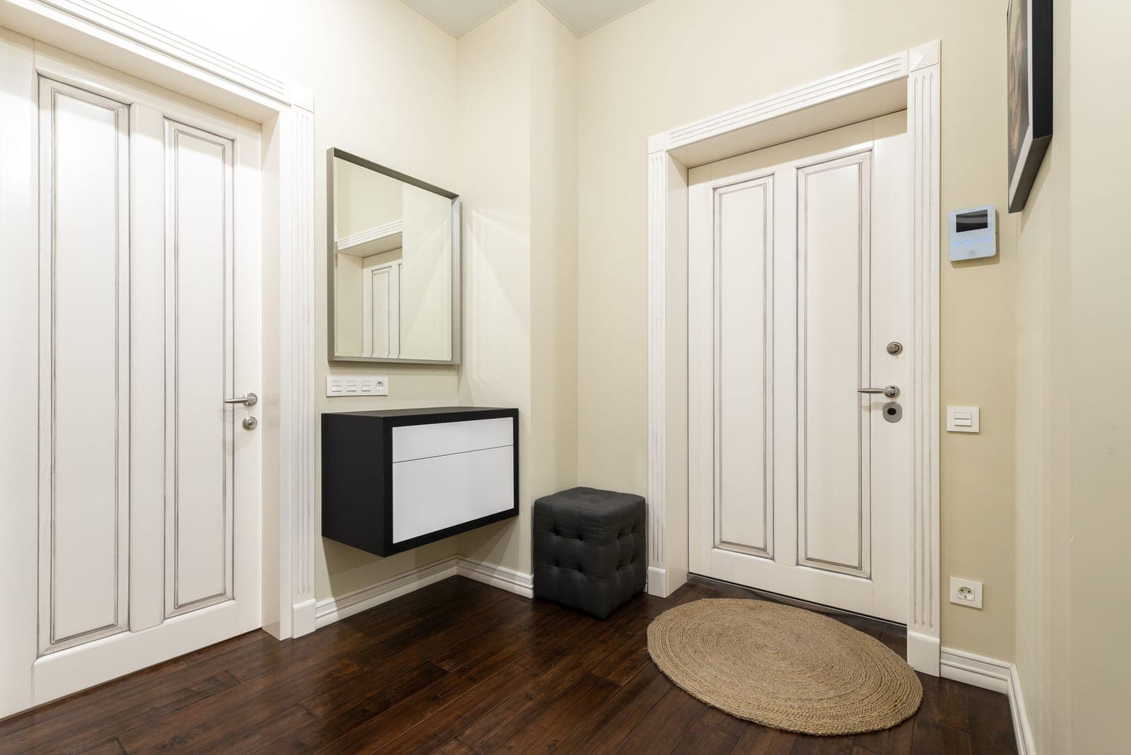 A modern hallway interior with a long carpet runner over parquet flooring
