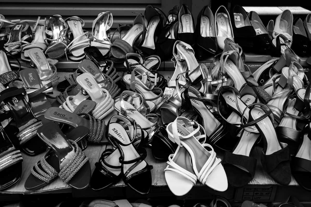 An open shoe rack holding shoes and boots in a home entryway
