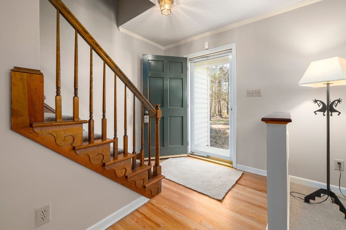 An absorbent entryway mat inside a front door with wet shoes on it
