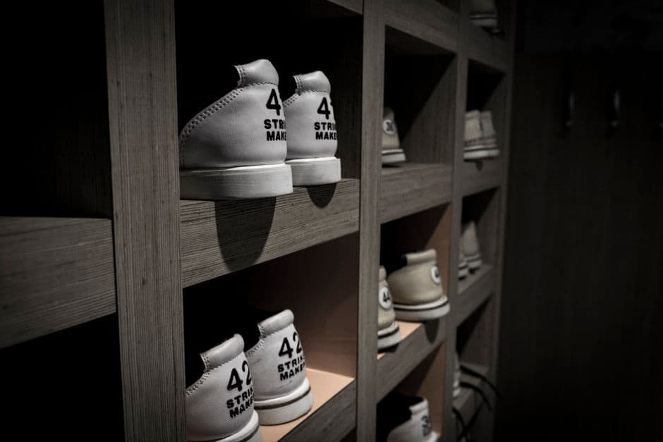 Shoes organized on open wooden shelving, one pair labeled with its size