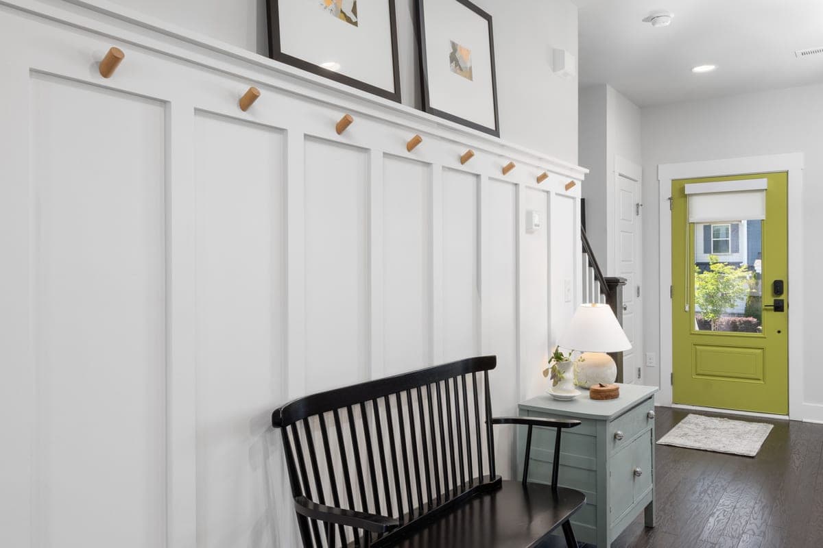 An organized entryway drop zone with a bench, mat and shoe storage