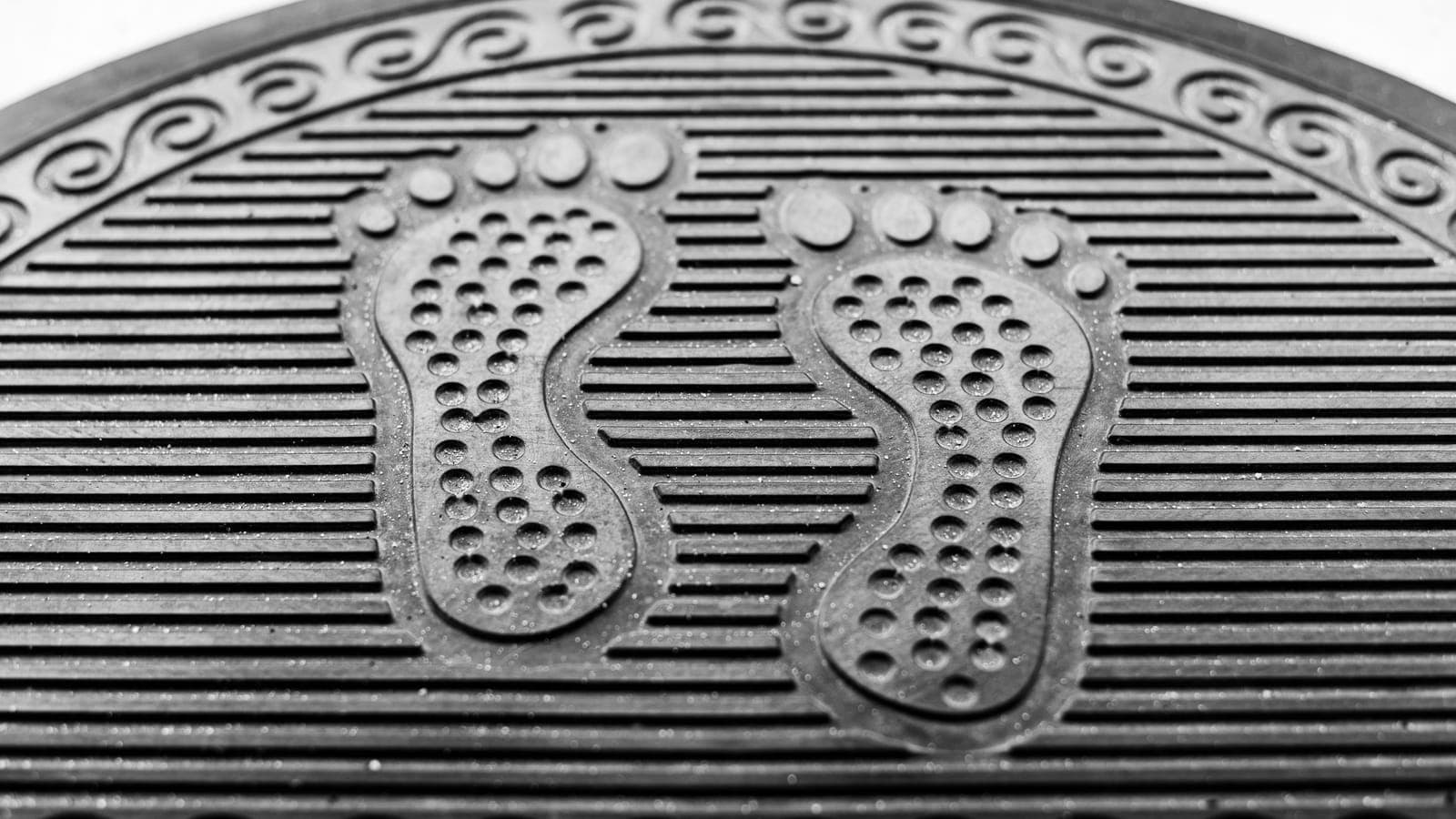 Close-up of a textured rubber door mat surface at a house entrance