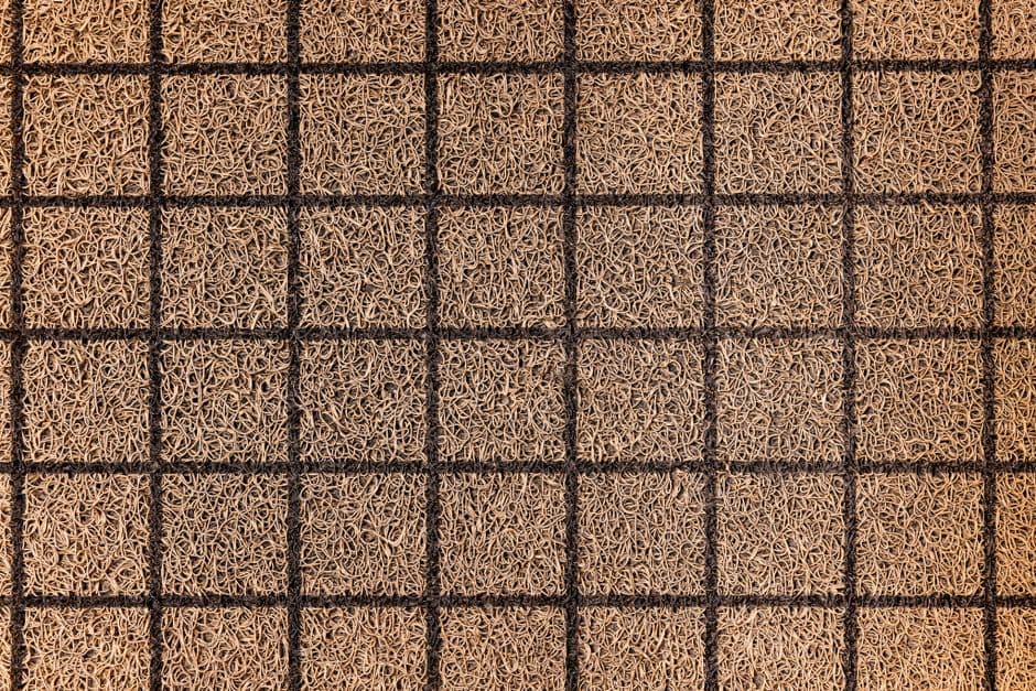 Overhead close-up of a woven coir doormat showing the coconut fiber weave