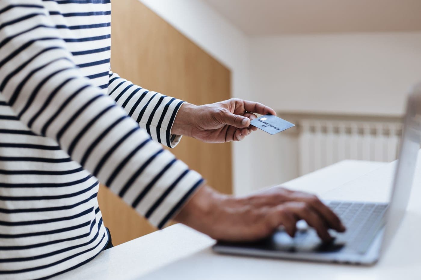 Someone shopping online with a laptop and a card