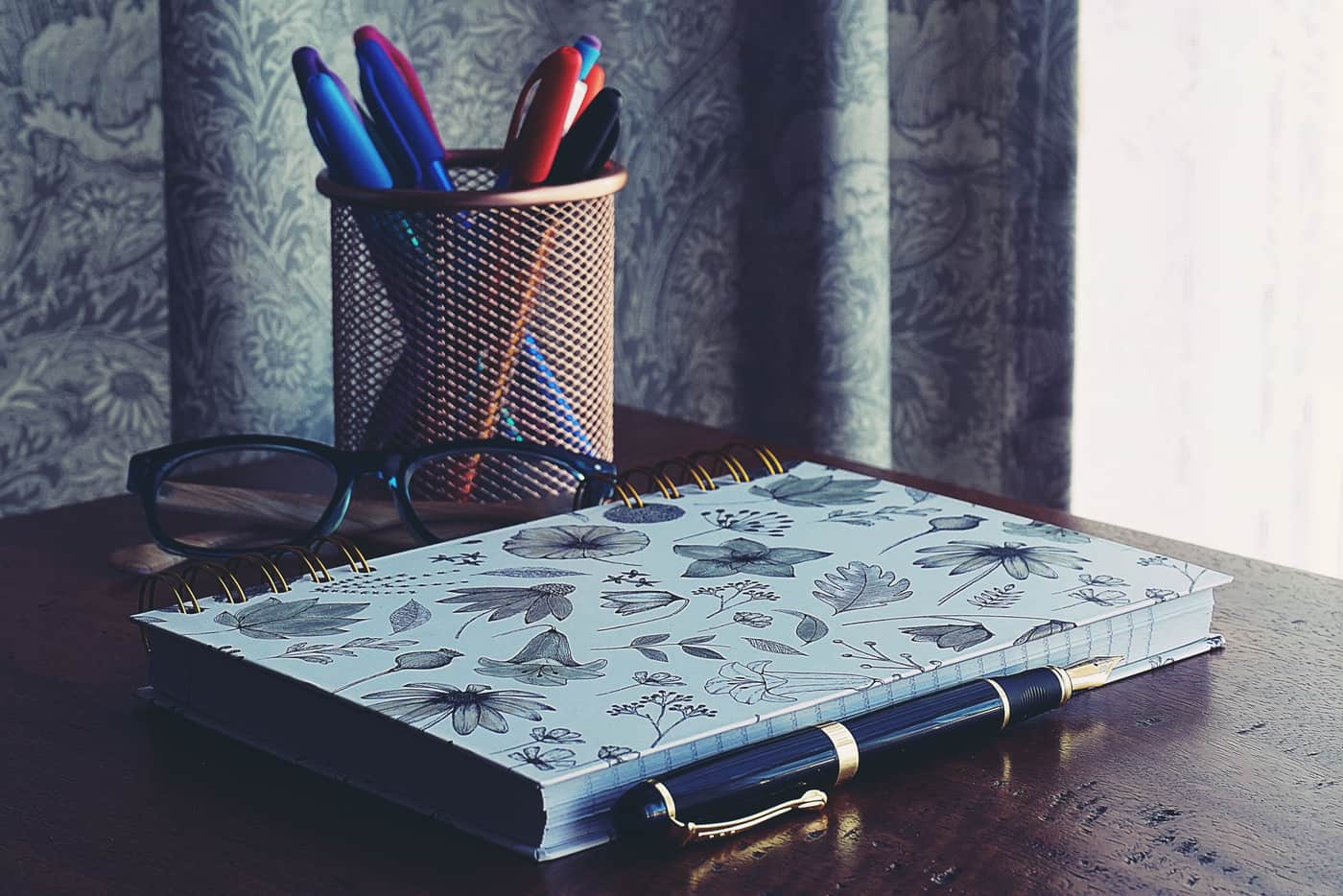 A notebook and pens on a desk